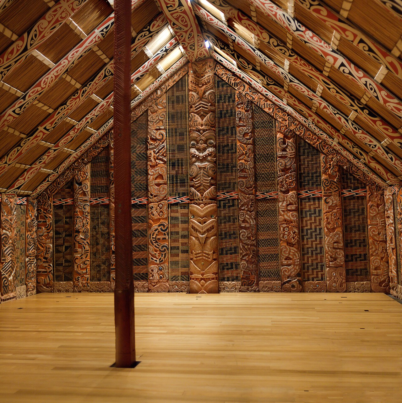 Εσωτερικό σπιτιού συνάντησης στο Auckland War Memorial Museum με ξυλόγλυπτα και διακοσμημένη στέγη